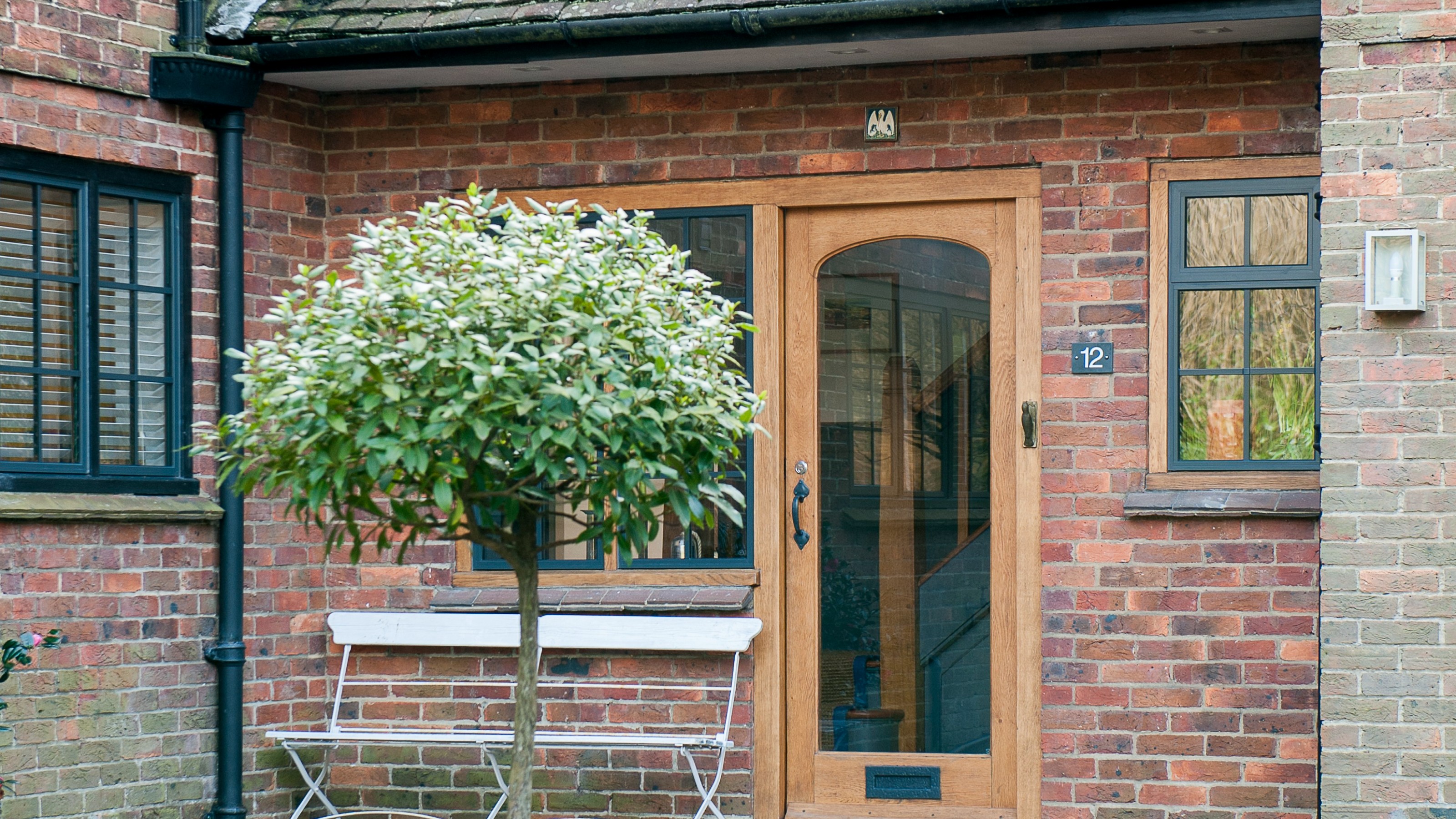 A front porch with a white garden bench and partly glass front door