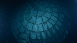 A close up of a circular heat shield made of interlocking rectangular components seen underwater.