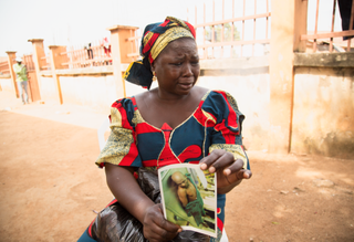 Woman holding picture of husband shot dead by Boko Haram