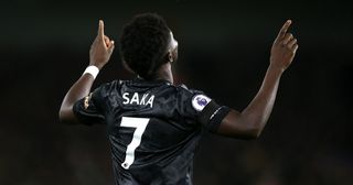 Bukayo Saka of Arsenal celebrates after scoring the team's first goal during the Premier League match between Brighton & Hove Albion and Arsenal FC at American Express Community Stadium on December 31, 2022 in Brighton, England.