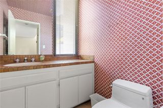 A bathroom with a red and white mosaic tile and a white vanity