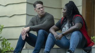 Chris Smith and Leota Adebayo sitting on a porch in Peacemaker season 2