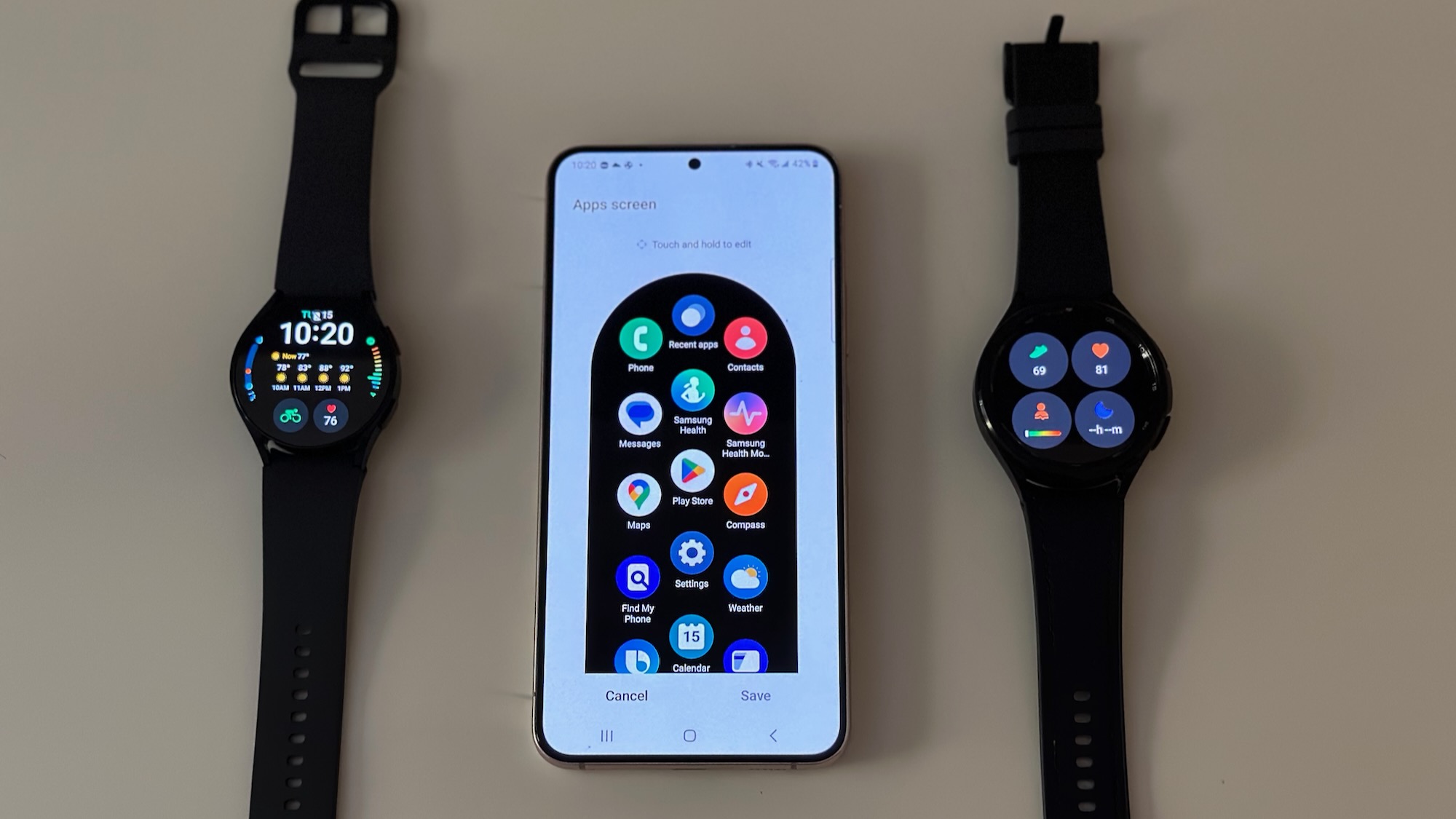 Samsung Galaxy Watch 6 and Watch 6 Classic, sitting on both sides of the Galaxy S22+ phone show the Galaxy Wearable app, specifically the way to change the app settings on the Galaxy Watch.