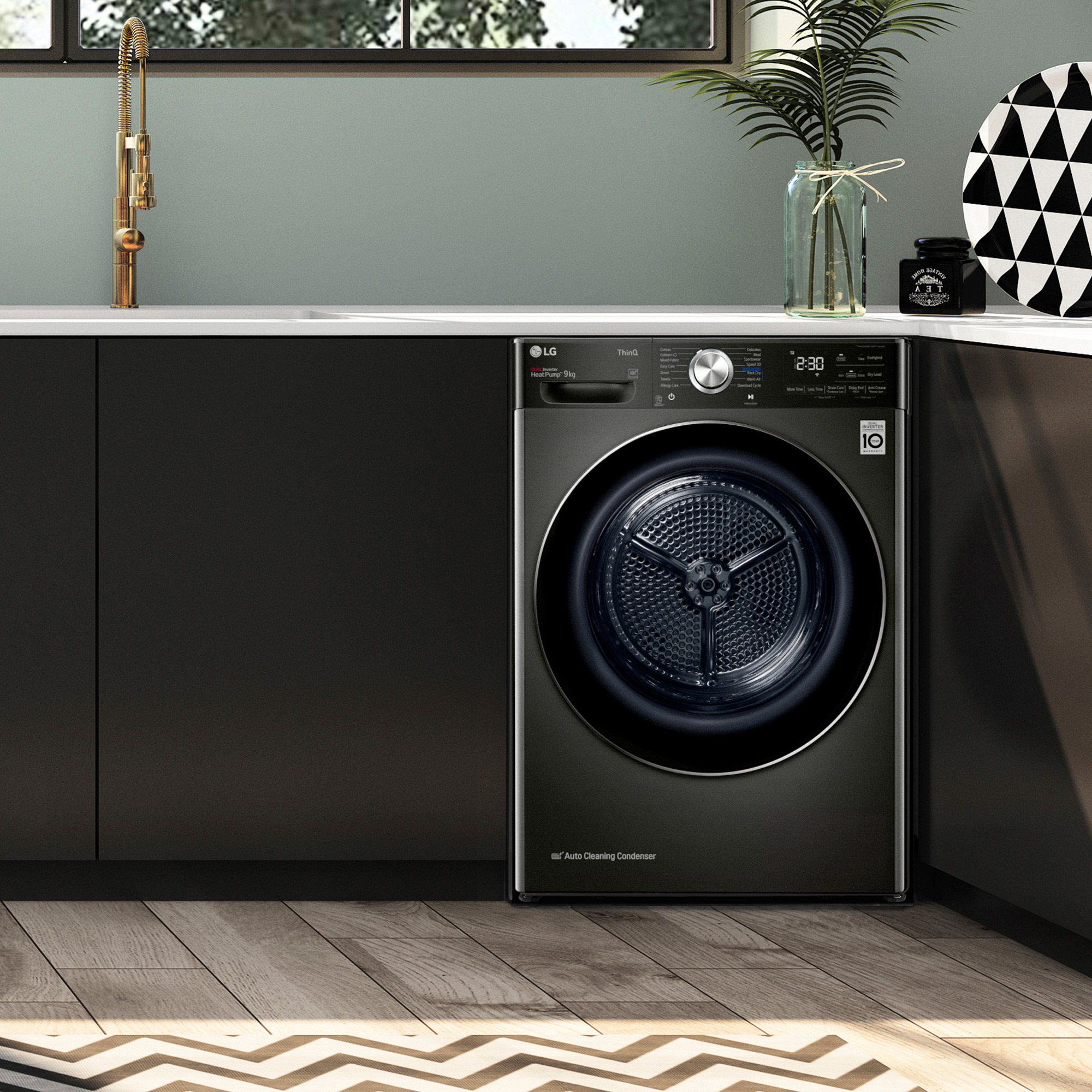 a black and sage green kitchen with a black LG tumble dryer