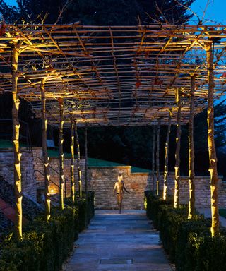 pergola made from bamboo canes over path with lighting by John Cullen Lighting