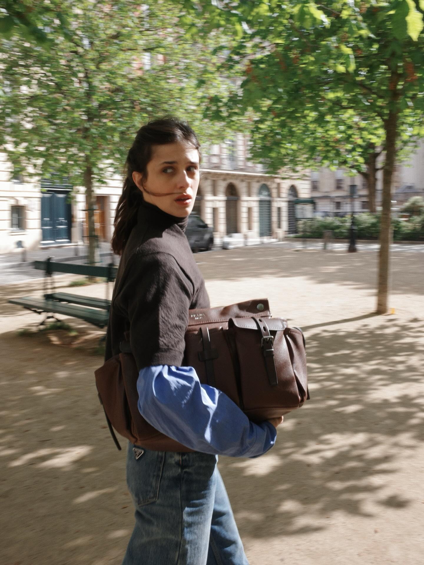 @bennipi wearing a brown top with jeans and carrying her brown leather Prada Route bag.