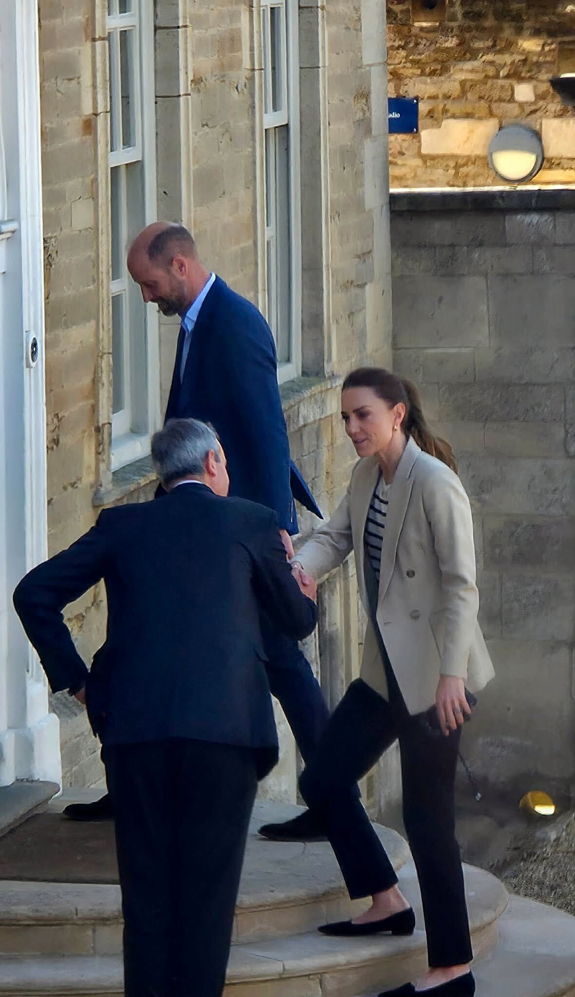 Princess Kate shaking hands with a man outside a house