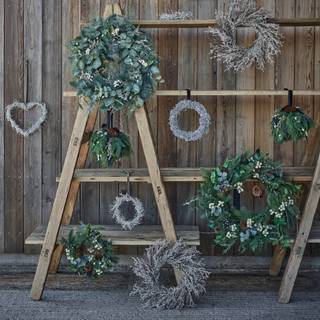 white company wreaths and garlands on wooden shelves