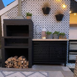 outdoor patio with tiled wall and log storage