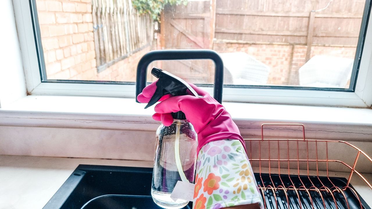 A cleaning spray bottle next to a sink