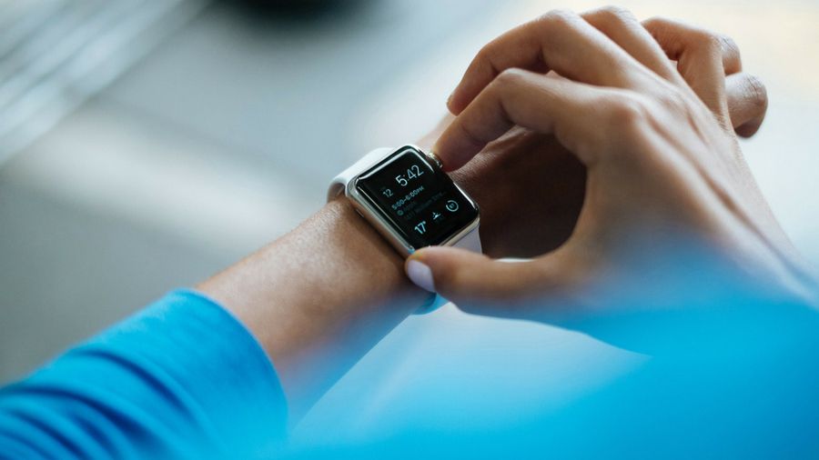 Image of hand pressing a button on a smartwatch