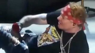Axl Rose lying on stage having fallen over