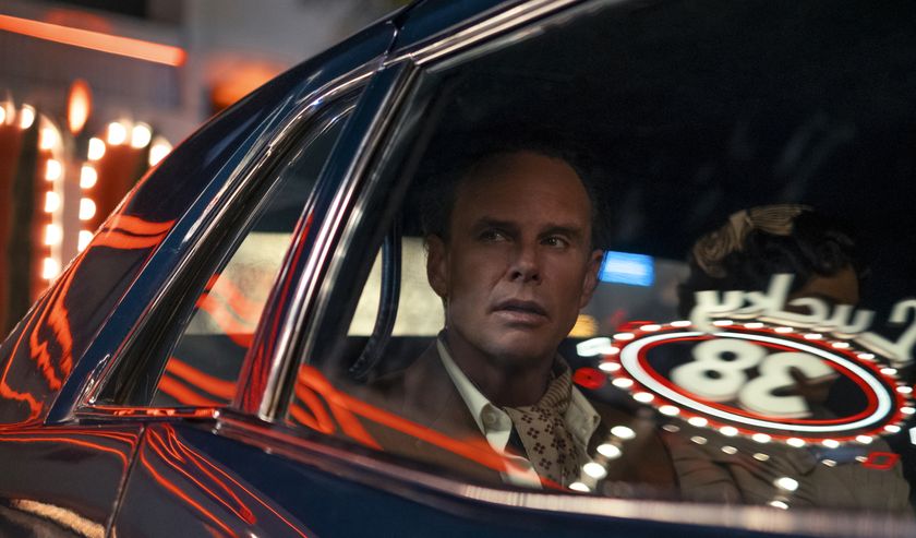Walton Goggins in a car with the window reflecting the Lucky 38 casino