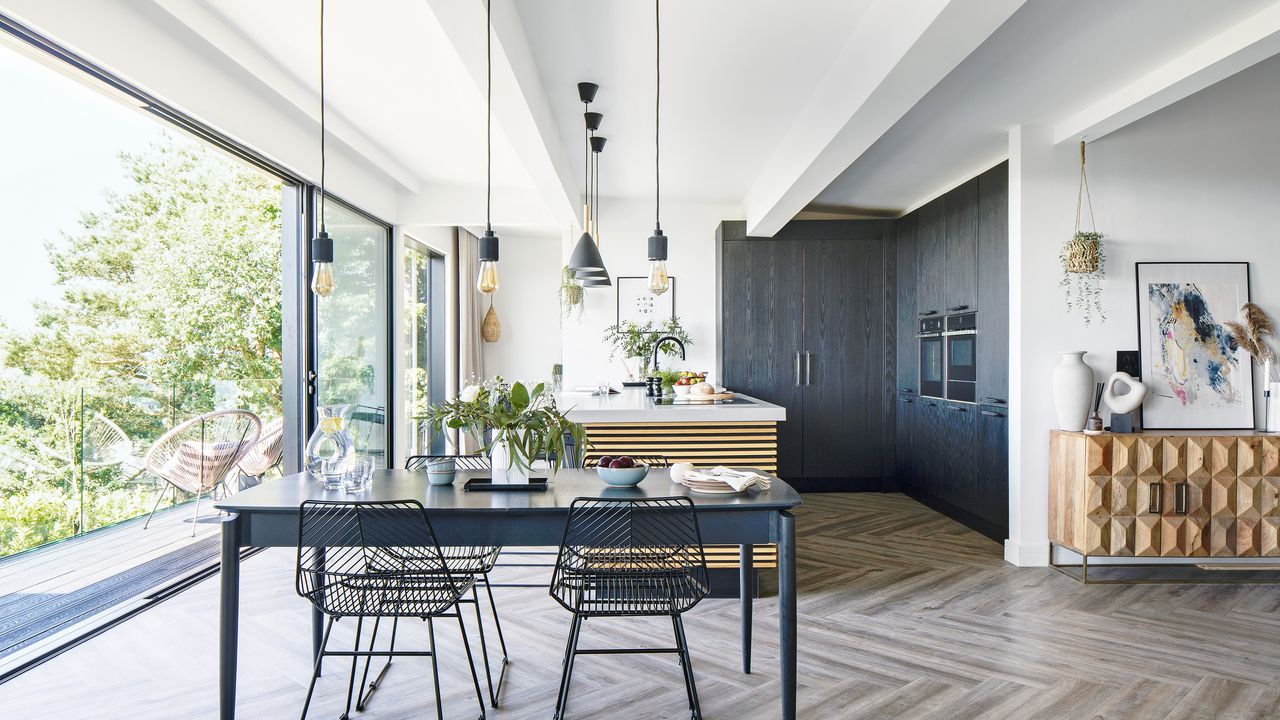 a contemporary open-plan kitchen diner with open patio doors that lead into a garden