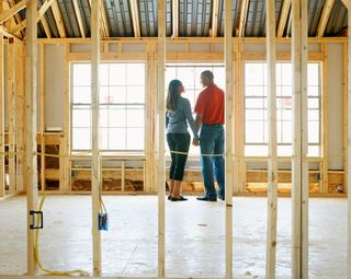 Couple holding hands in home under construction