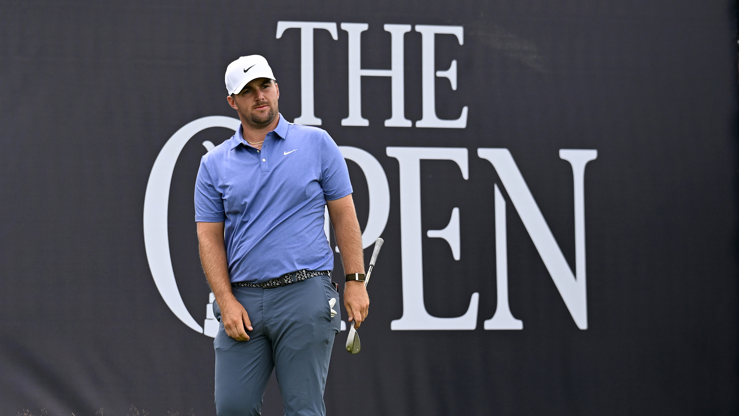 Chris Gotterup looks on with a big The Open sign behind him