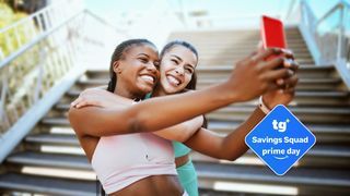 Two women who look happy looking at a phone.