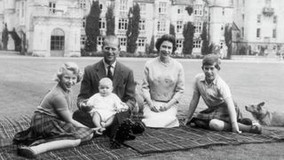 Queen Elizabeth and Prince Philip, Duke of Edinburgh with their children, Prince Andrew, Princess Anne and Charles, Prince of Wales sitting on a picnic rug outside Balmoral Castle