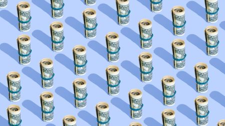 Repeated rolls of American dollars on a blue background