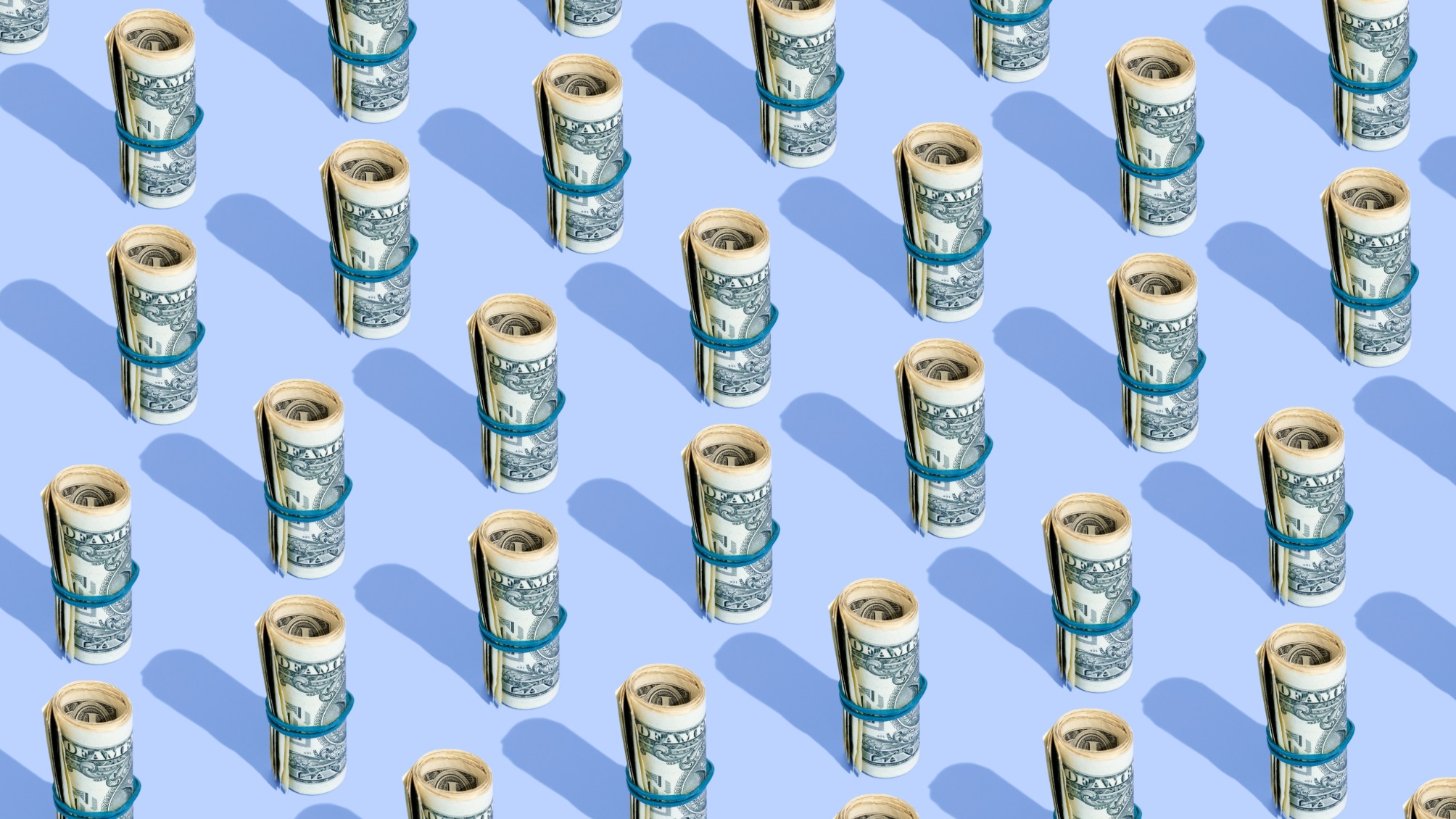 Repeated rolls of American dollars on a blue background
