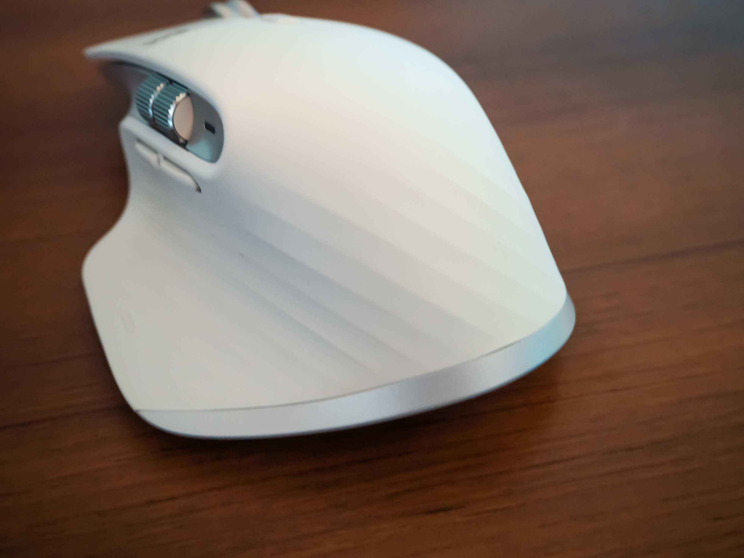 A white Logitech MX Master 3S for Mac mouse on a brown wooden desk