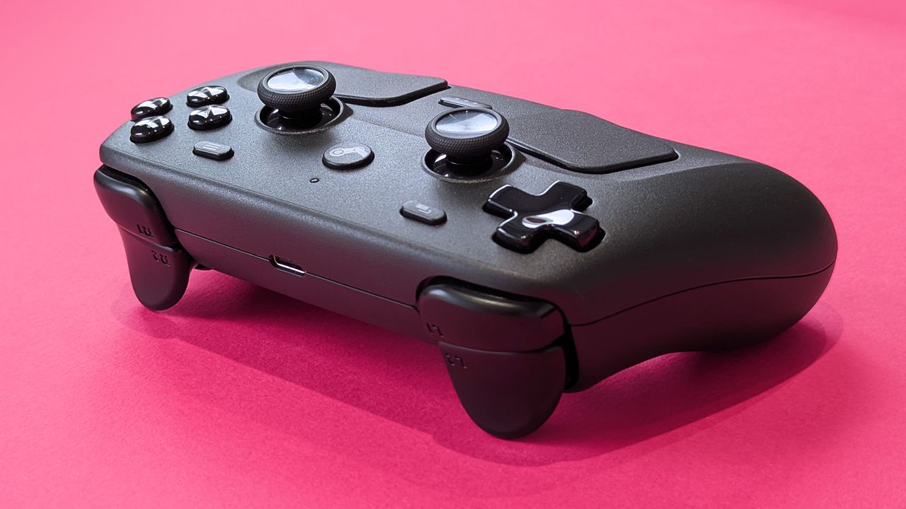 Close-up of the triggers and shoulder buttons of the Valve Steam Controller (2026) against a magenta card background
