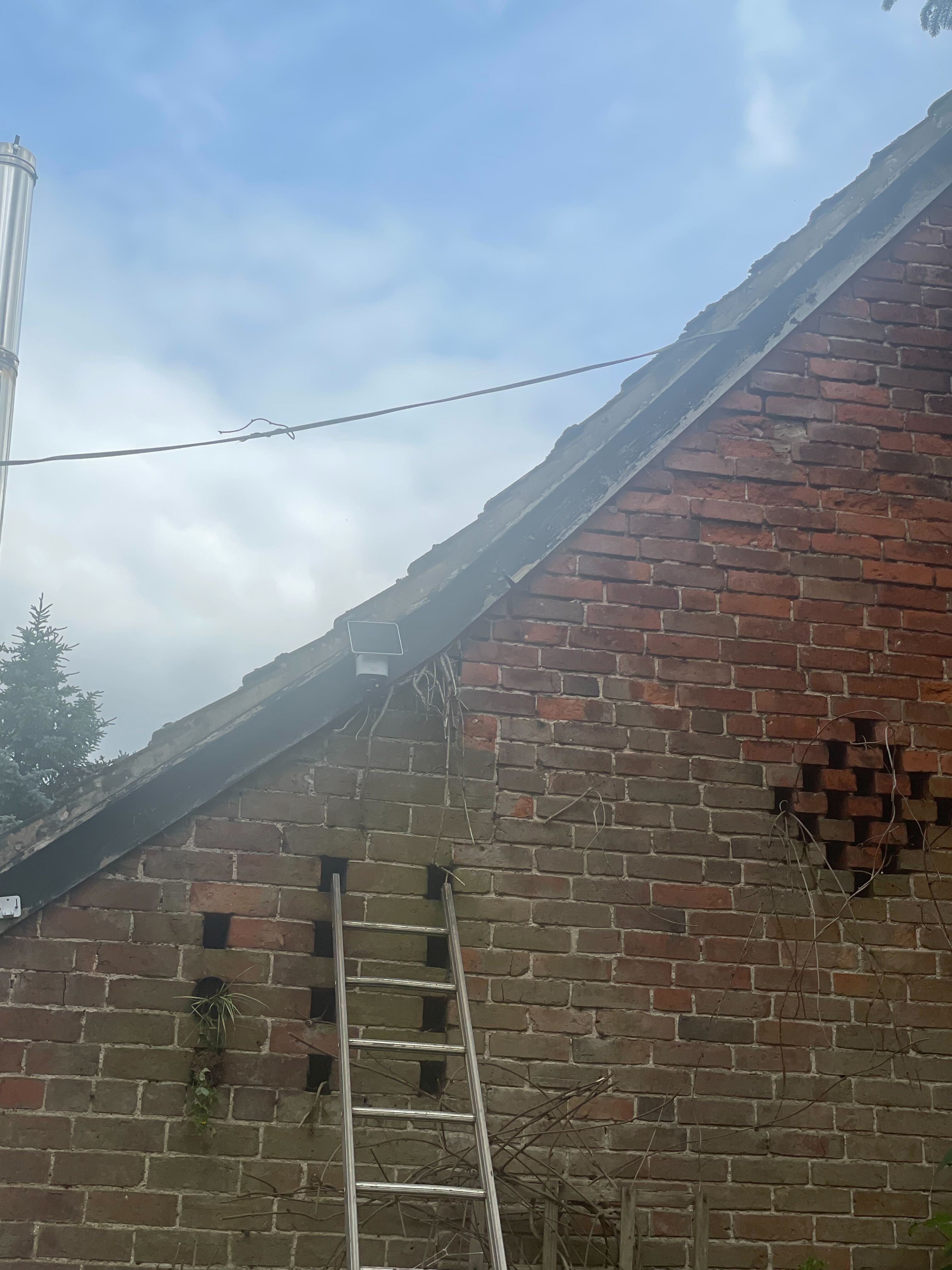 A security camera with solar panel on a wall