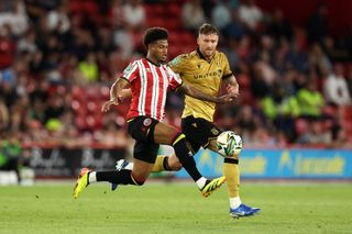 SHEFFIELD, ENGLAND - AUGUST 13: Rhian Brewster of Sheffield United battles for possession with Dan Scarr of Wrexham during the Carabao Cup First Round match between Sheffield United and Wrexham at Bramall Lane on August 13, 2024 in Sheffield, England.