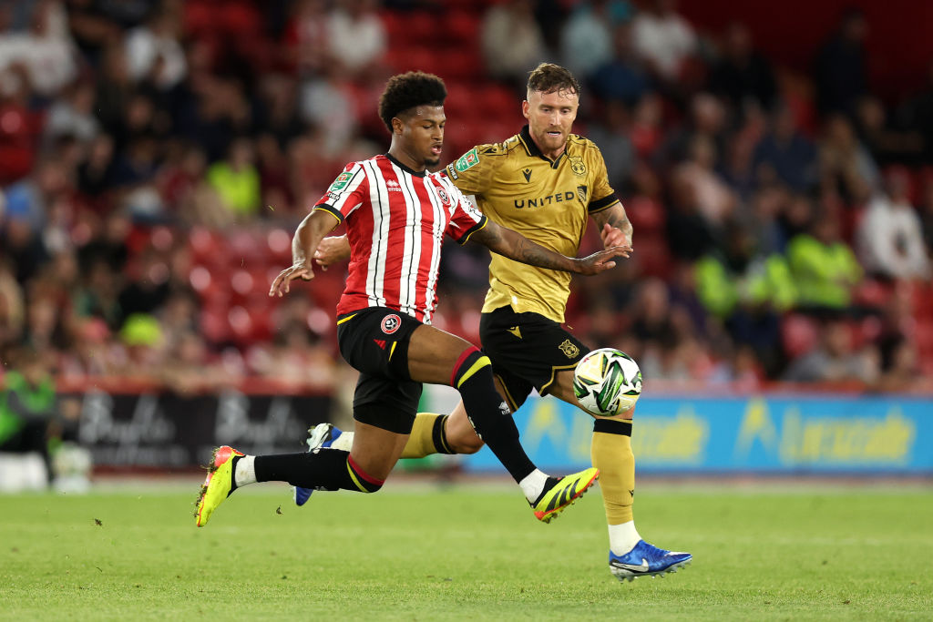 SHEFFIELD, ENGLAND - AUGUST 13: Rhian Brewster of Sheffield United battles for possession with Dan Scarr of Wrexham during the Carabao Cup First Round match between Sheffield United and Wrexham at Bramall Lane on August 13, 2024 in Sheffield, England.