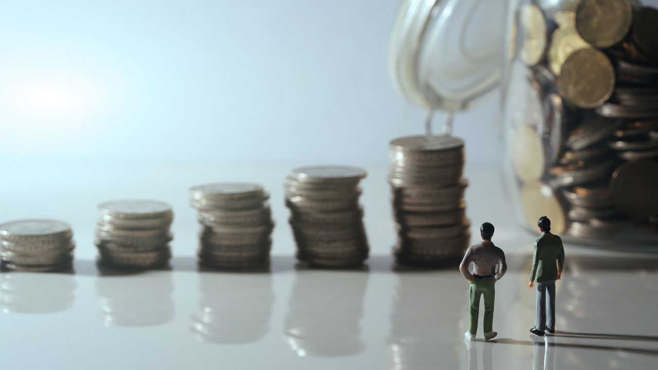 Figures looking at pile of coins