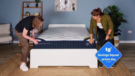 The image shows two mattress testers unboxing the new DreamCloud Classic Hybrid mattress. Inset to the right is a blue Tom's Guide Savings Squad Prime Day badge 