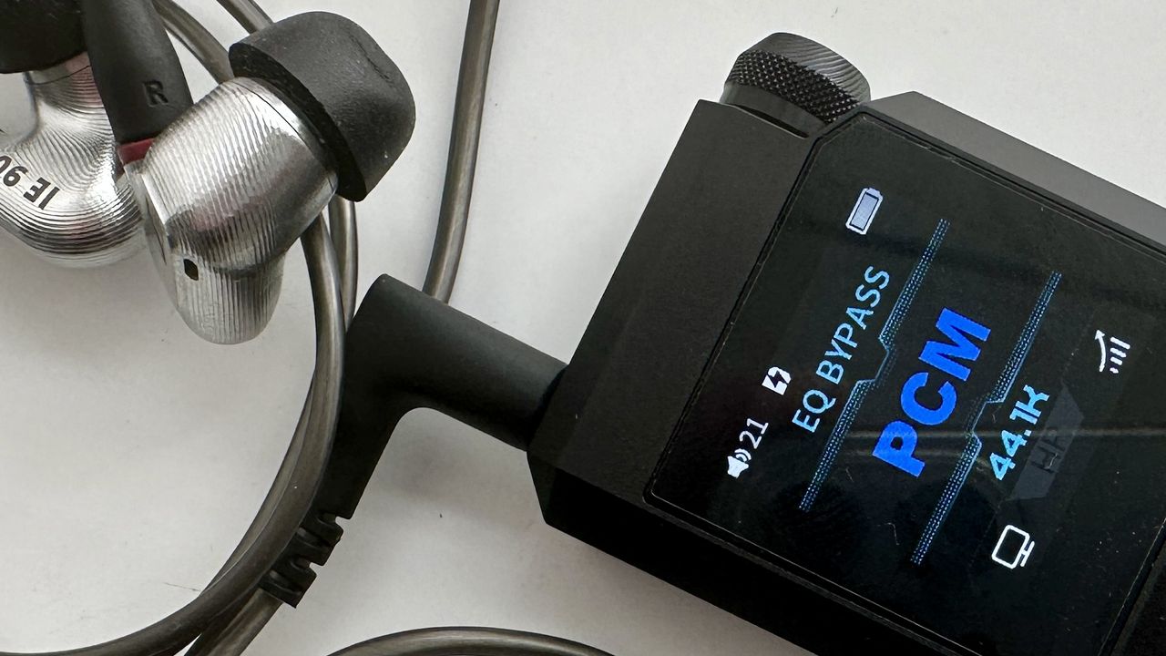 FiiO's BTR17 DAC/amp in black, on a gray table, showing PCM resolution in yellow font