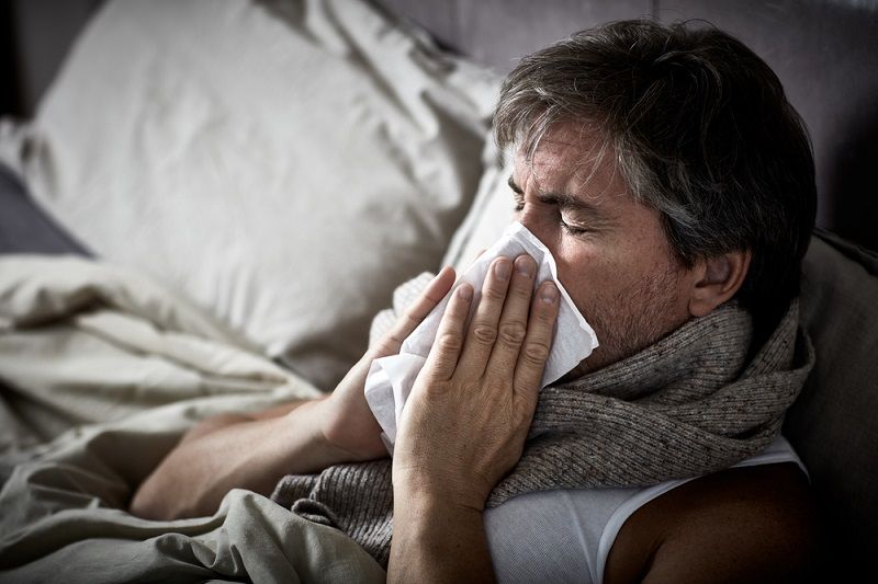 A man in bed with the flu.