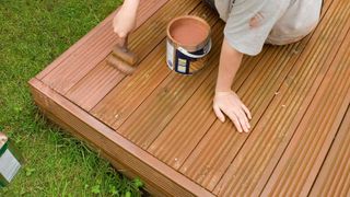 woman painting composite decking brown