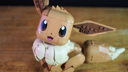 Lego Eevee sat on a wooden table, smiling into the foreground