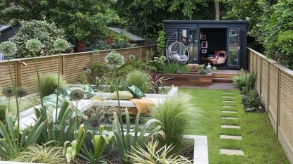 garden with shrubs, plants, grassland and grassland in front of a brick house