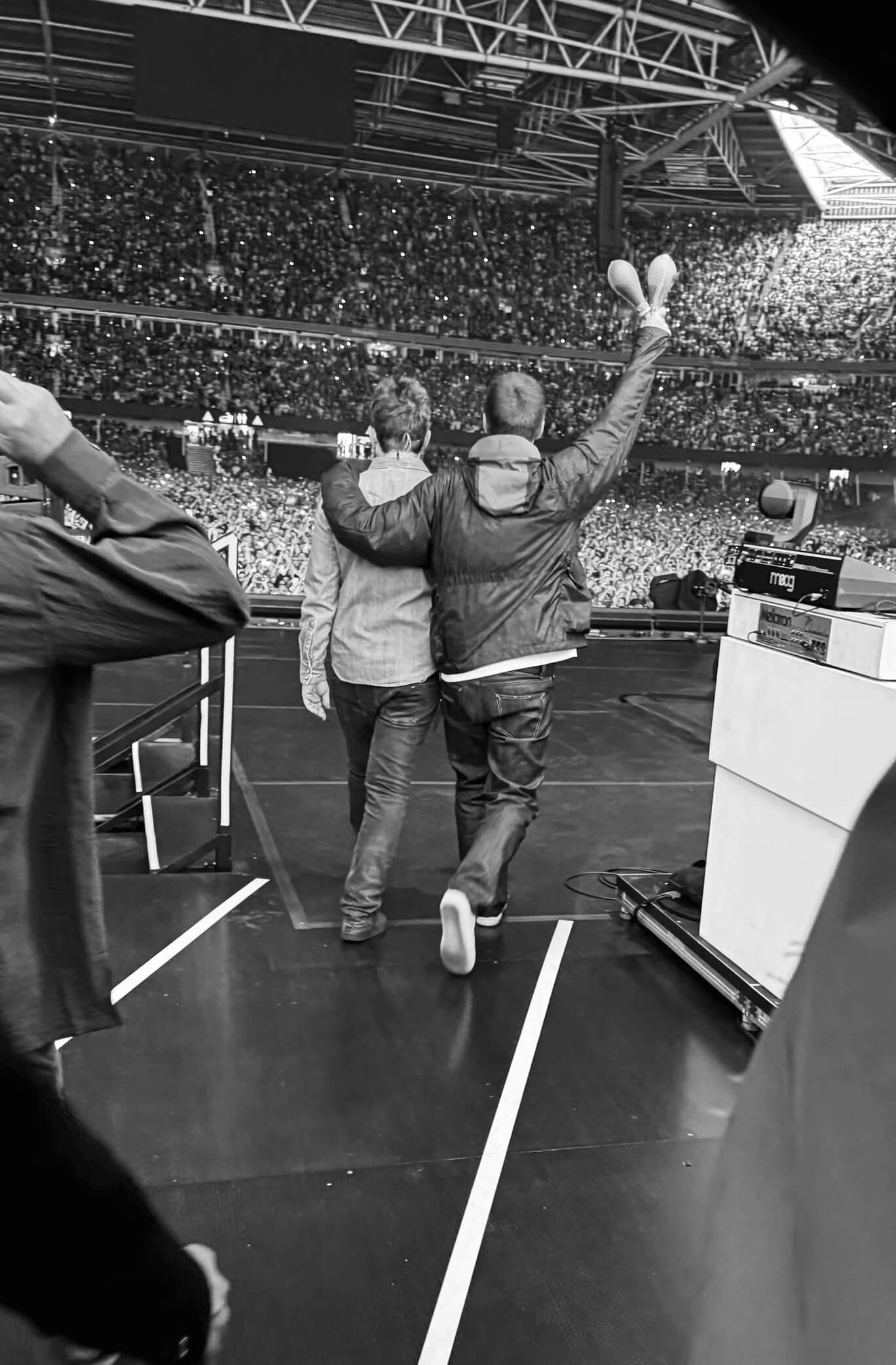 Oasis walking into stage taken from behind.