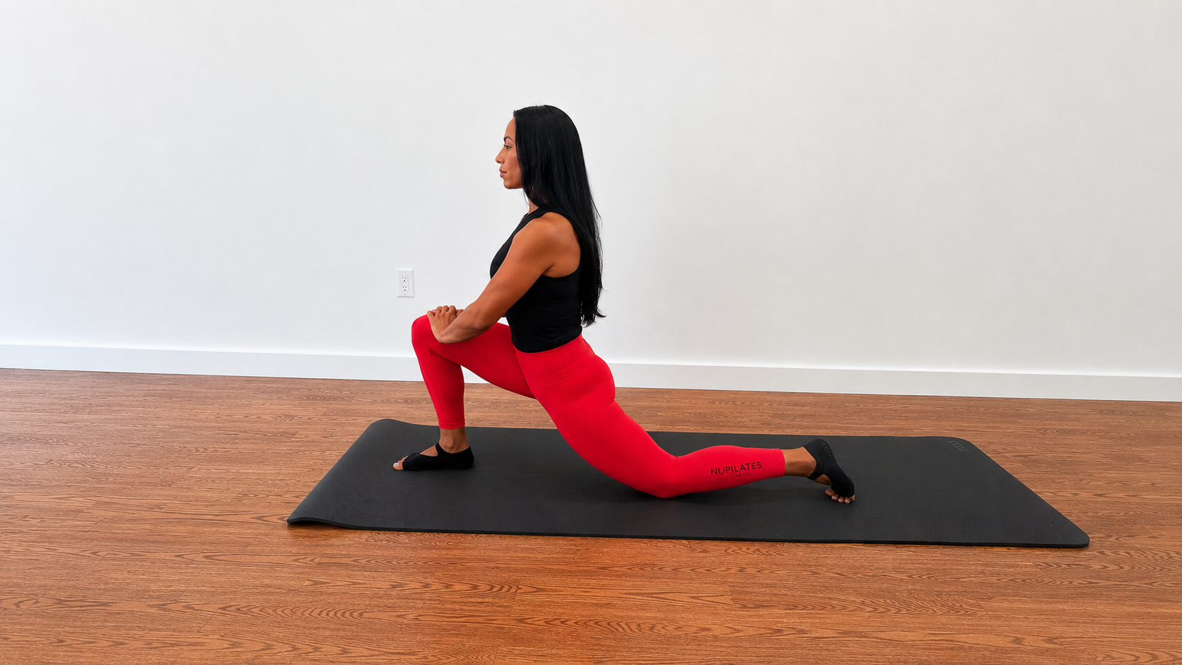Nicolle Lopez-Lamberty performs a low lunge on an exercise mat.