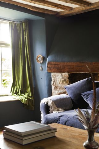 living room with velvet sofa and green curtain window detail