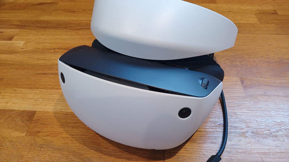 PSVR 2 review; a white VR headset on a wooden table