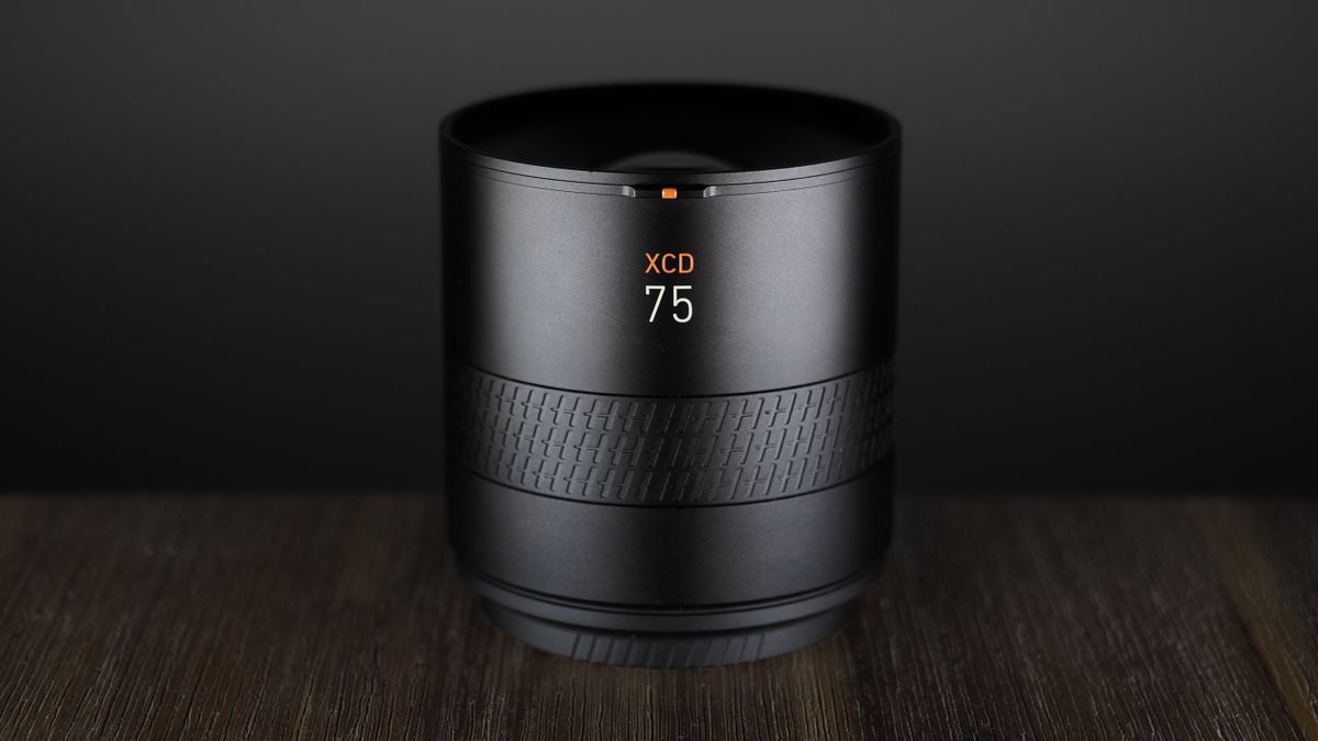 Hasselblad XCD 75P lens, on a wooden surface, against a dark background