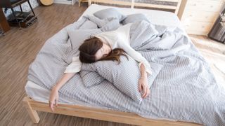 Woman sleeping at the end of bed