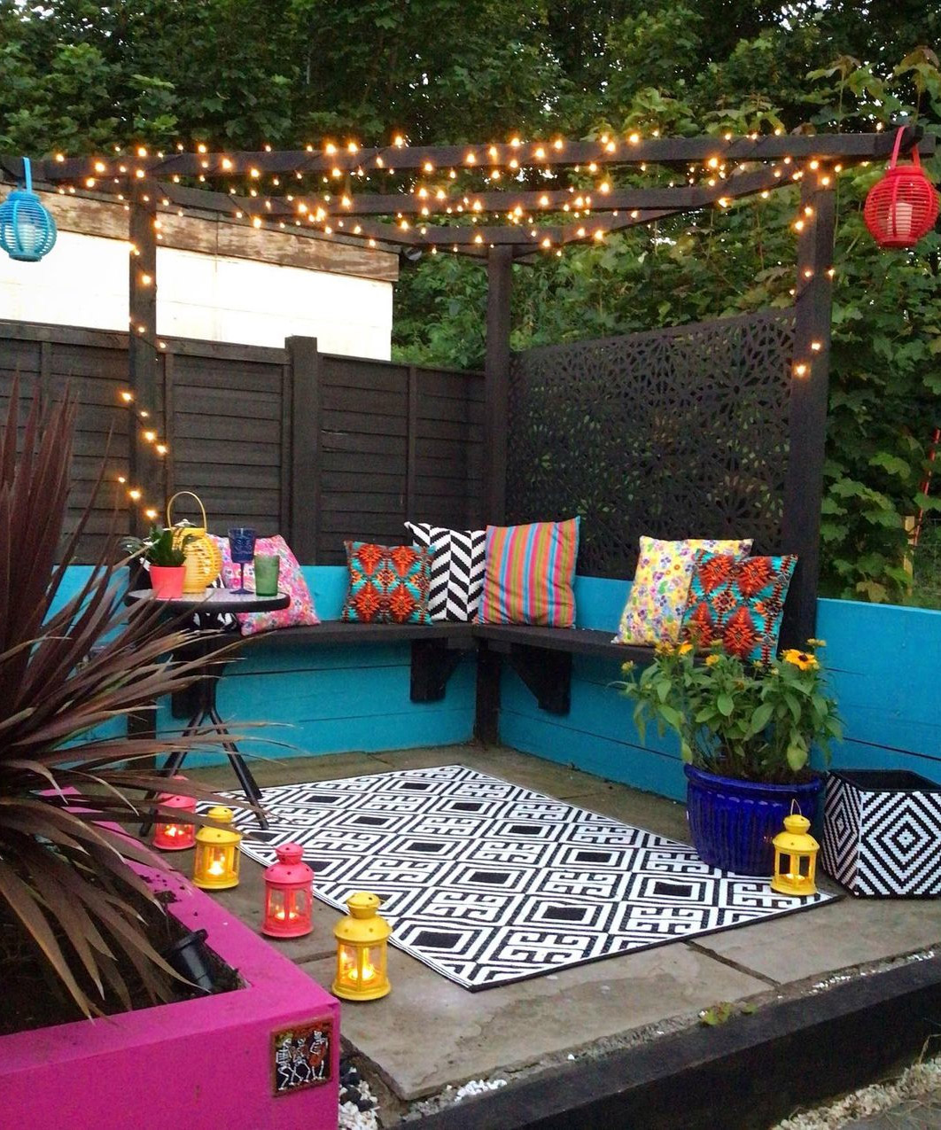 patio area with blue and pink painted walls and an outdoor rug and outdoor cushions