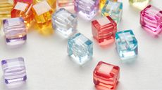 Multicolored crystal cubes scattered on a white background.
