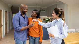 couple taking keys from estate agent in house