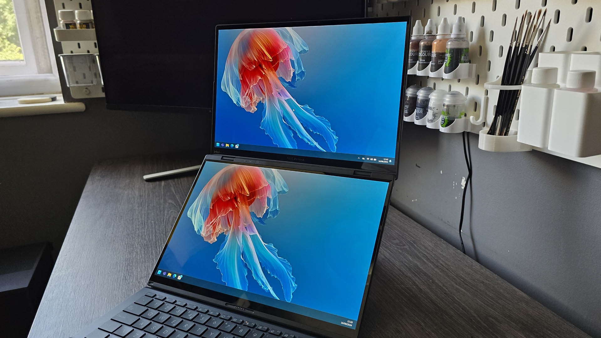 The Asus Zenbook Duo laptop photographed on a wooden desk.