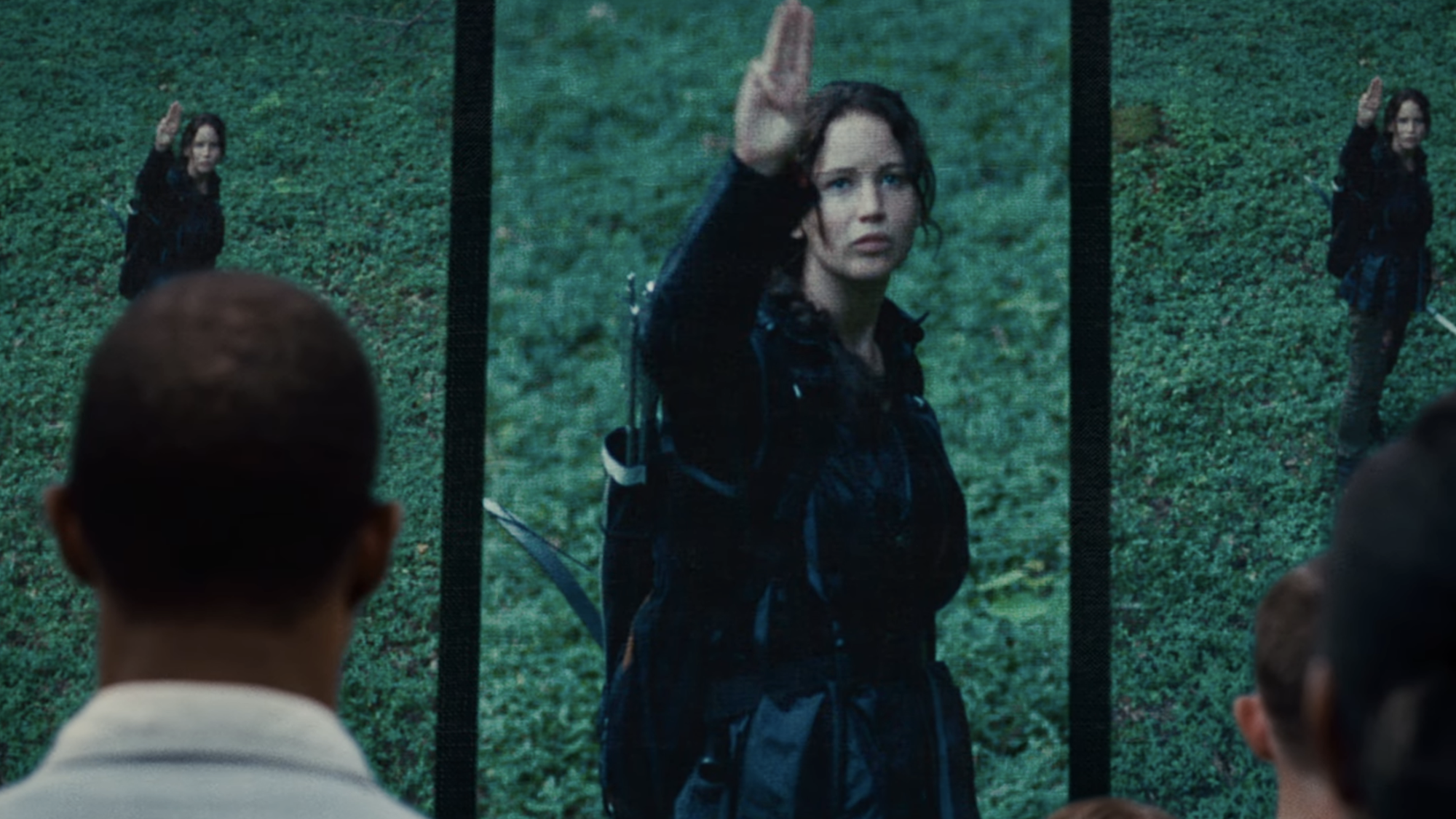 Jennifer Lawrence as Katniss Everdeen throwing up the three-finger signal in The Hunger Games