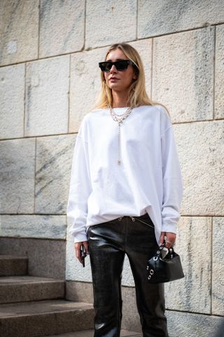 woman wearing a white t shirt and leather pants