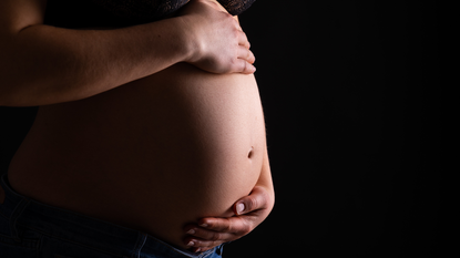 In this photo illustration, a pregnant woman shows her belly.