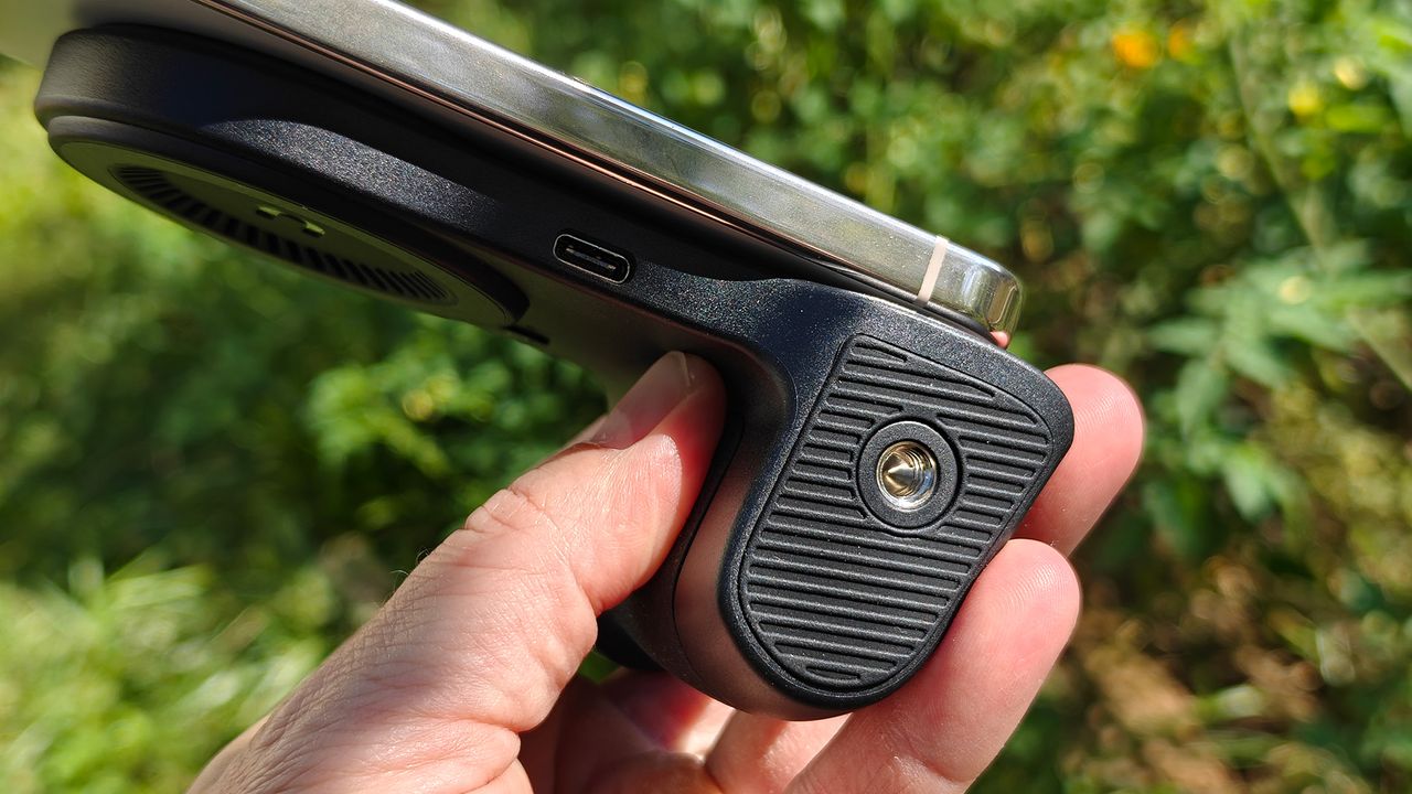 The bottom of a KraftGeek magnetic camera grip showing its USB-C port and standard tripod screw mount